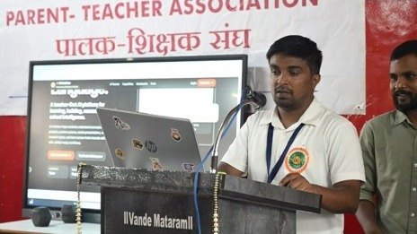 A presenter speaking beside a presentation display