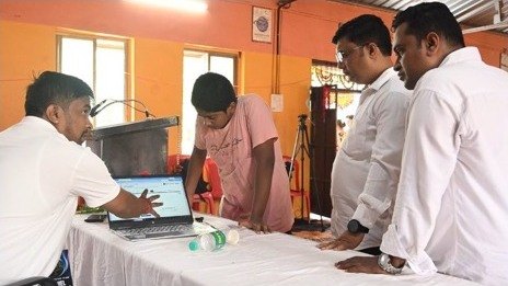 Participants looking at a laptop demonstration during the session